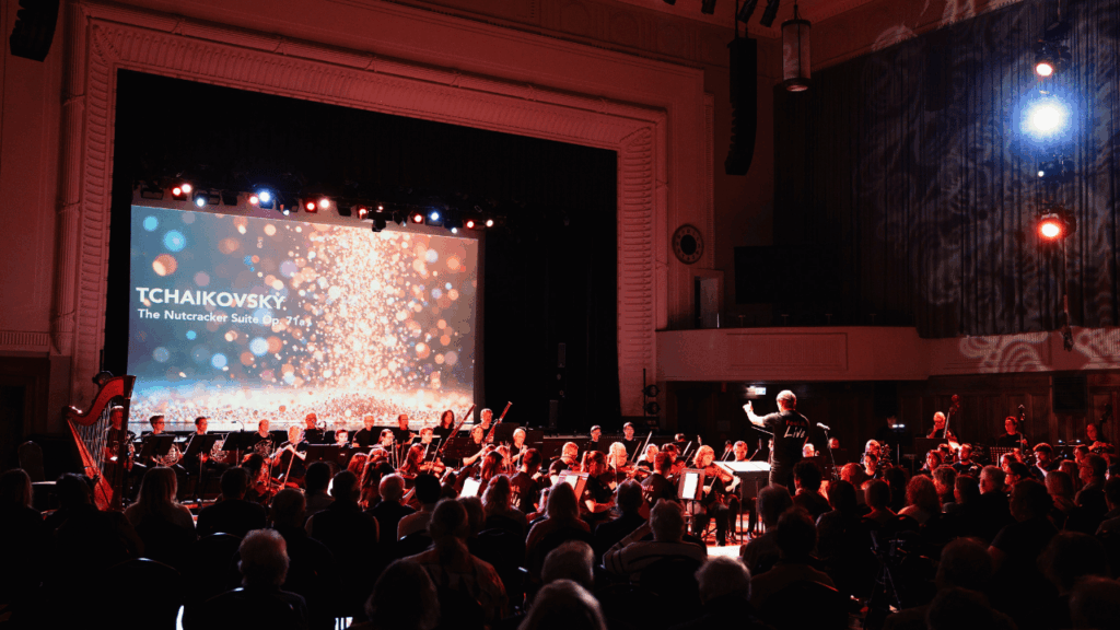 An orchestra performing on stage in front of an audience